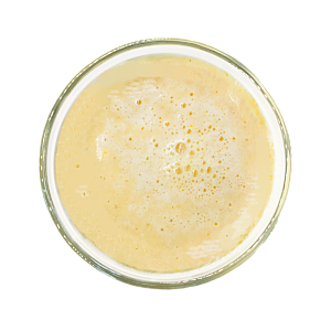 Top view of a white frozen craft smoothie in a glass by Living Farmacy.