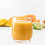 Image of flow craft smoothie in glass with fruits and vegetables in background,
