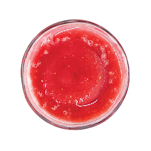 Top view of red frozen craft smoothie in a glass by Living Farmacy.