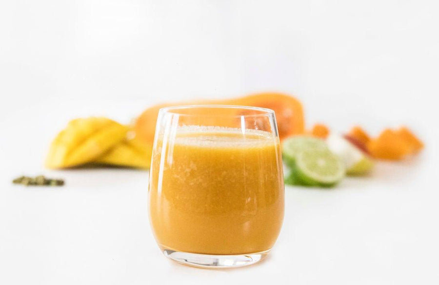 Image of flow craft smoothie in glass with fruits and vegetables in background,