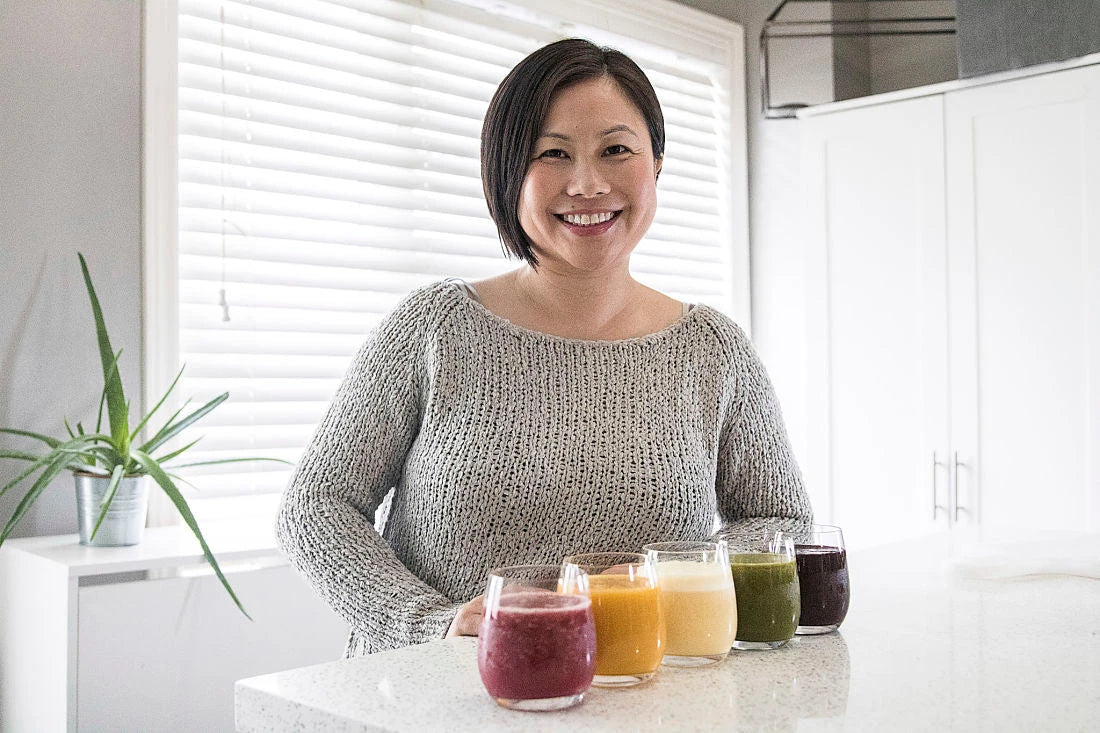 Kim Chung in her kitchen with five Living Farmacy smoothies